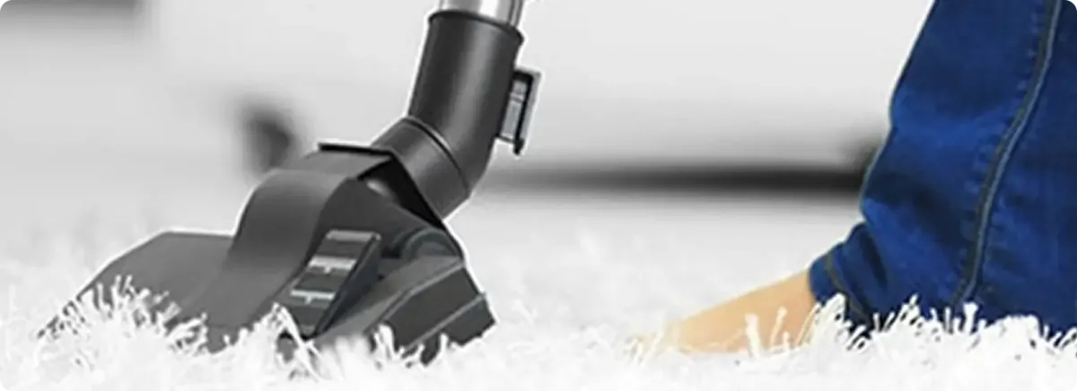 Close-up of a professional vacuuming a white carpet in Garden Grove.